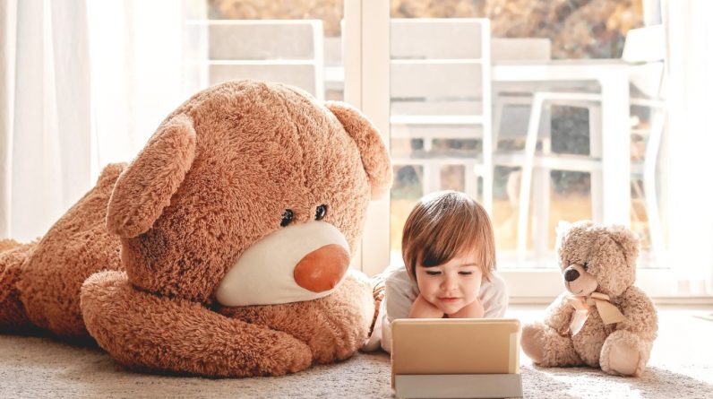 nominated cute little child watching cartoons on digital tablet device lying on floor with two soft t20 kRprbK